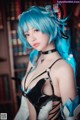 A woman with blue hair wearing a black and white outfit.