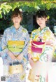 A couple of women in kimonos standing next to each other.