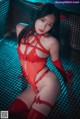 A woman in a red latex outfit posing in a pool.