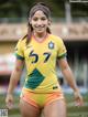 A woman in a yellow and green soccer uniform posing for a picture.