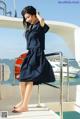 A woman in a sailor outfit standing on a boat.