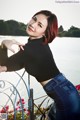 A woman leaning on a railing by the water.